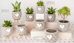 Incantevole Bomboniera Matrimonio Portapiante in Ceramica con Cuore a Rilievo 02a230-02a231-02a232 Set di tre modelli di portapiante in ceramica decorata con motivi geometrici e cuore centrale bianco, contenenti piante grasse succulente.