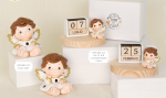 Composizione di angeli paffuti in resina con ali dorate, versione con calendario perpetuo in legno e versione con luce LED su basi circolari in legno.