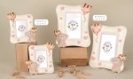Dolce Portafoto da Battesimo Bimba Pupo Orso Rosa 04A497 - 04A499 Composizione di quattro portafoto in resina sagomata bianca della collezione Pupo Orso Rosa, decorati con palloncini rosa tridimensionali e scritte emozionali interne, ideali come bomboniere da battesimo.