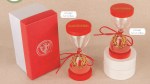 Bomboniera Laurea Clessidra Oro Alloro con Box Bomboniera laurea clessidra con sabbia rossa e corona d'alloro dorata, completa di scatola regalo rossa con logo oro. 07a261-a07262