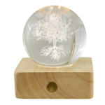 Bomboniera Lampada LED Sfera Cristallo Albero della Vita con Base Legno Lampada a sfera in cristallo con incisione 3D dell'Albero della Vita, appoggiata su una base quadrata in legno con illuminazione LED accesa.