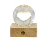 Bomboniera Lampada Globo Led Cuore in Cristallo con Base in Legno Lampada a sfera in cristallo con cuore interno e base quadrata in legno.