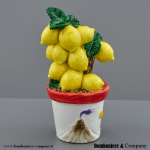 Bomboniera Matrimonio Piantina Grassa in Stile Siciliano con Limoni e Vulcano Etna 1240374 omboniera da appoggio in stile siciliano alta 12 cm con vaso bianco decorato con il vulcano Etna e composizione di limoni gialli brillanti con foglie verdi.