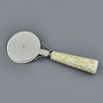 Il Tagliapizza Barocco per Matrimoni 1317003 Tagliapizza stile barocco con lama circolare in acciaio e manico in ceramica bianca con eleganti decorazioni floreali color oro e beige, ideale come bomboniera utile per matrimoni ed eventi.